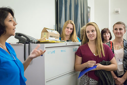 Callie Nance, 15, center, and some of her high school classmates toured Professor Sayantani Ghosh's lab before the Dinner with a Scientist event.