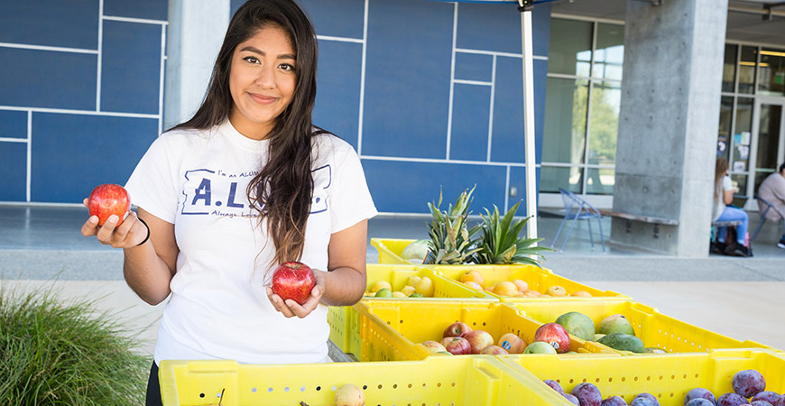 Student behind a produce stand