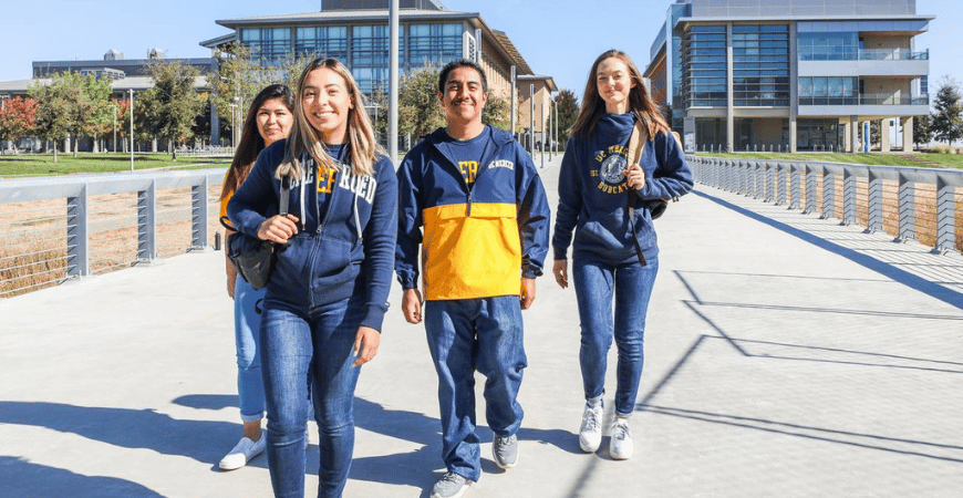 Student walking across a bridge on campus