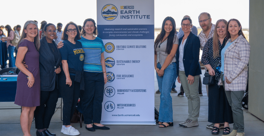 Members of the Earth Institute posed next to a branded sign