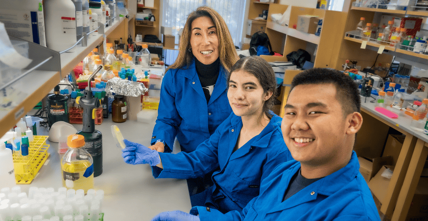 Two students and their professor in a UC Merced research lab.